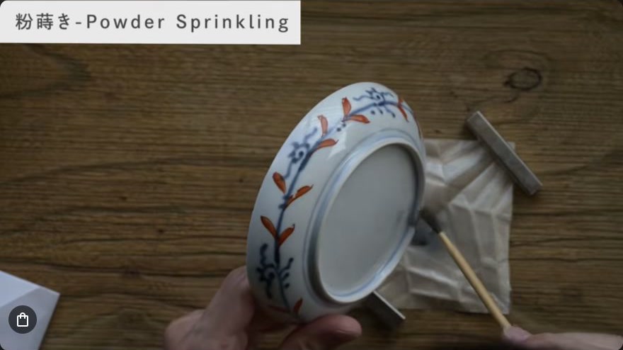 Sprinkle metal powder (maki-e) — Platinum powder is sprinkled directly onto the tacky lacquer line with a fine brush.
