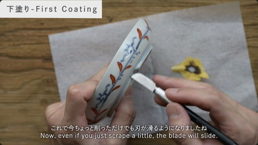 Trim, level, and abrade the filler — A blade is held nearly flat while shaving the cured filler level with the surrounding glaze.