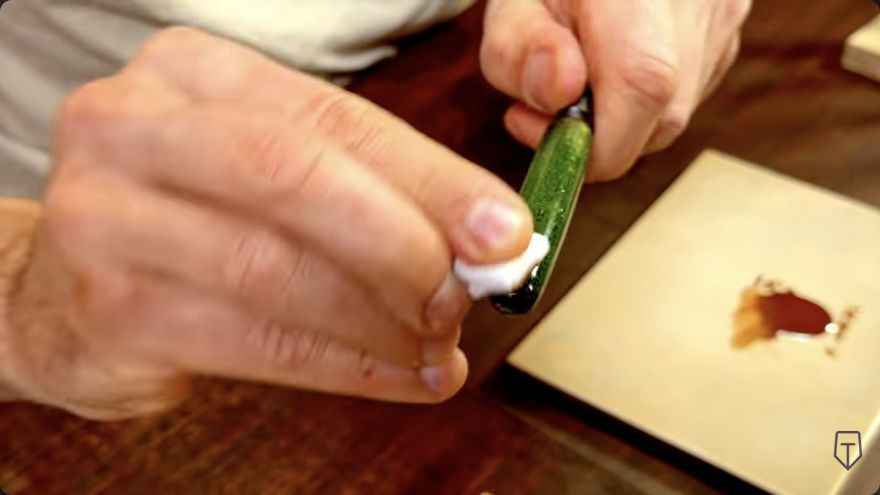 Apply lacquer to the surface — A cloth applicator rubs a thin lacquer layer into the pen surface.