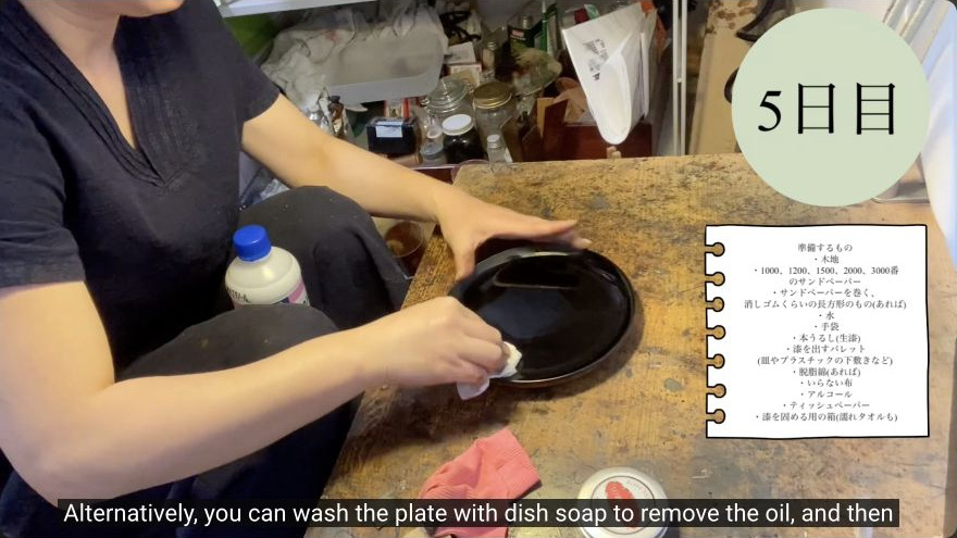 Remove oil residue and prepare for suri-urushi — The maker wipes the polished lacquer surface to remove the oily cream residue before applying ki-urushi.