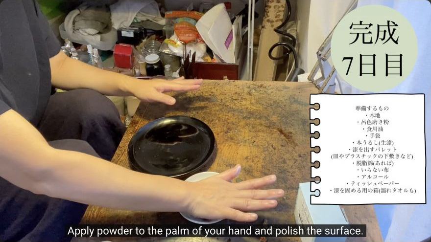Final hand-polishing with oil and powder — The maker applies polishing powder to the palm and works it across the lacquered surface by hand.