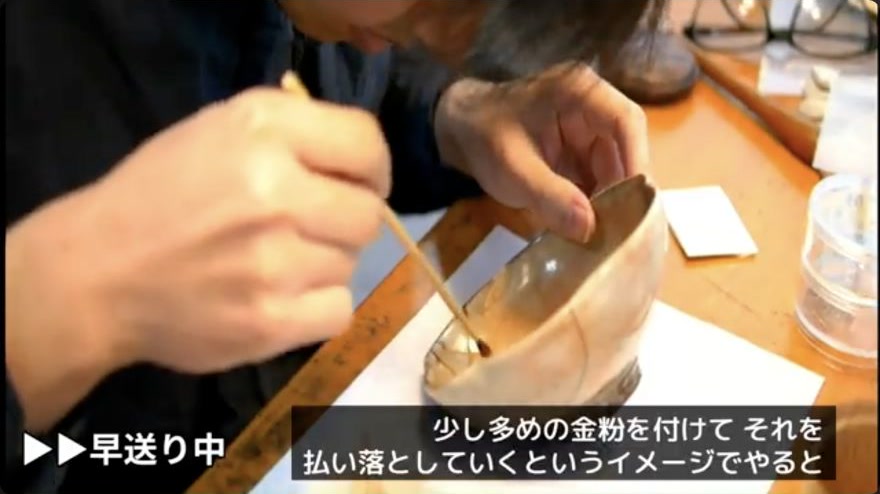 Remove excess powder — The kebo sweeps loose powder away from the decorated line without disturbing the adhered metal.